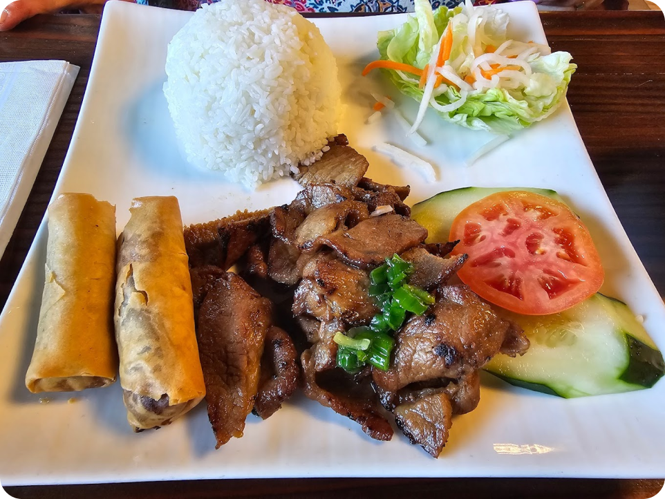 rice, grilled chicken, tomatoes, vegetables, and spring rolls